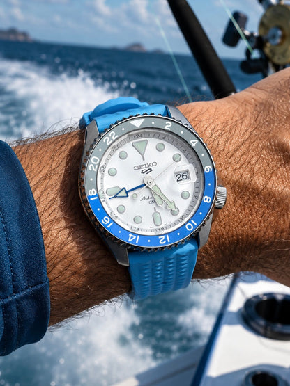 Blue waffle FKM rubber watch strap on a men’s wrist in a marine setting, premium waterproof watch band with vintage-inspired texture.