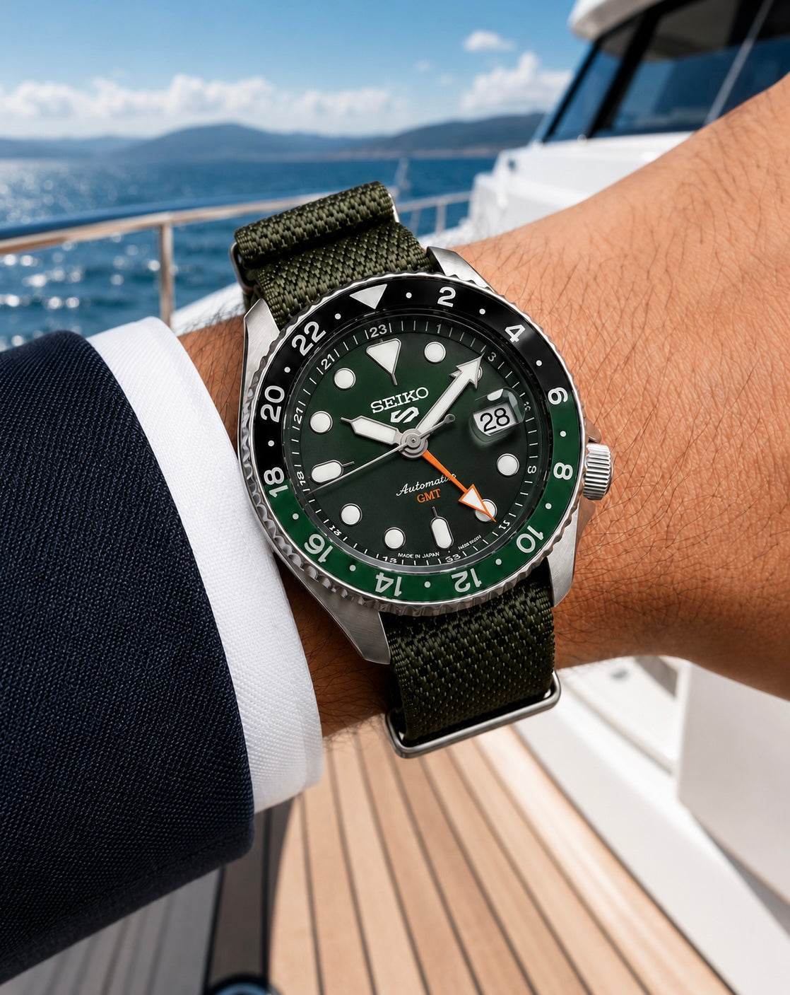 Montre Seiko GMT à cadran vert avec bracelet NATO vert portée au poignet sur le pont d’un bateau.